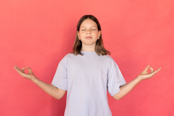 画像平静的青春期前女孩穿着蓝色t恤冥想图片下载