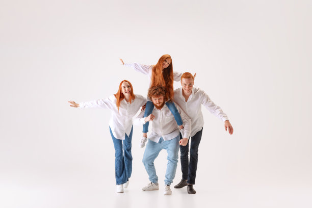 幸福的家庭，红头发的年轻男人，女人和孩子穿着休闲风格的衣服花时间在工作室的照片拍摄。图片下载