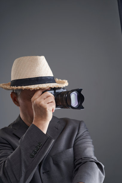 专业摄影师，头戴帽子，手持相机图片下载