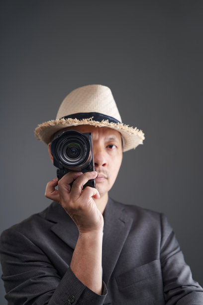 专业摄影师，头戴帽子，手持相机图片下载