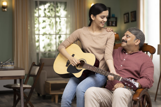 小女孩学习弹吉他与她的父亲在家里库存照片图片下载