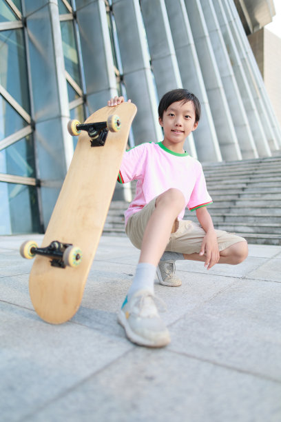 一个小男孩在城市的街道上滑冰图片下载