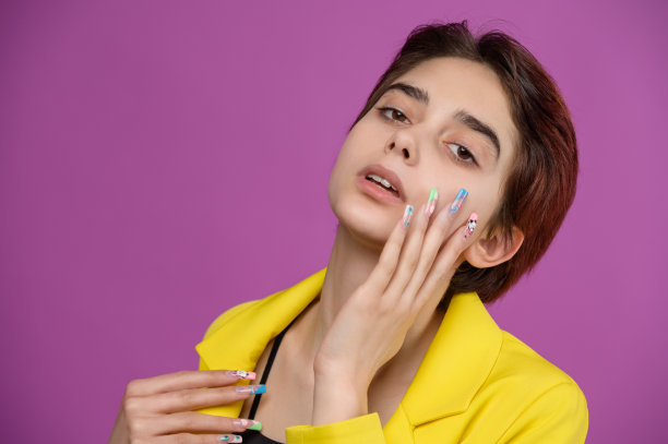 工作室肖像的年轻温柔的褐发女孩与奢侈的美甲艺术图片下载