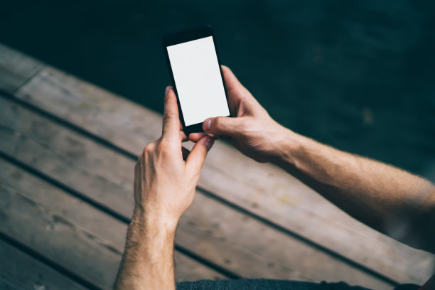 有人在户外浏览空白屏幕的智能手机图片下载