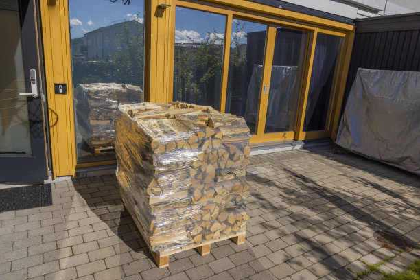 近景桦木在运输网包裹在塑料薄膜前的现代别墅外立面。瑞典。图片下载