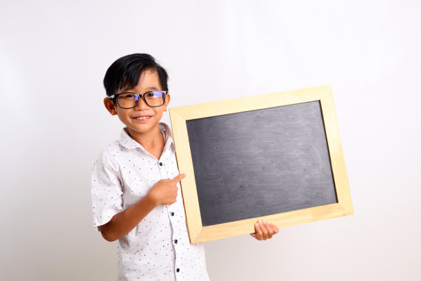 快乐的亚洲学生站着，展示一块空白的黑板。孤立在白色背景中图片下载