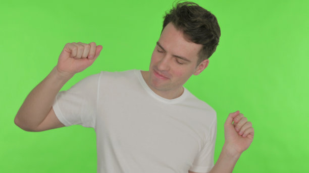 快乐的年轻人在绿色背景上跳舞图片下载