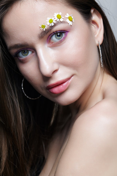 用小洋甘菊花装饰眉毛的女人。图片下载