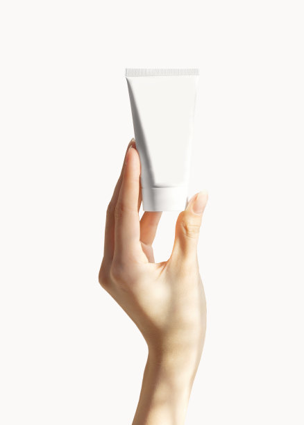 一个无标签的容器，用来装面霜，凝胶和洗发水。在一个孤立的背景中，一个女人的手拿着一个白色的塑料瓶。专业化妆品的包装。护肤概念。空间模型,复制图片下载