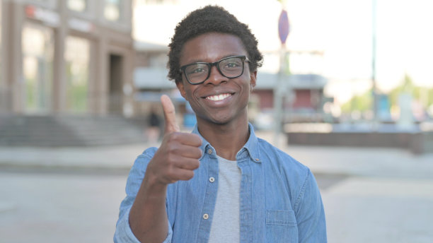 年轻的非洲男子站在户外竖起大拇指图片下载