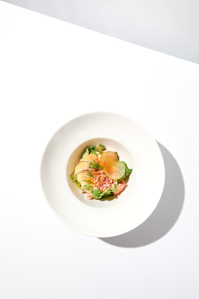 优雅的沙拉与蟹肉，espuma酱和生菜在白色的桌子上与强烈的阴影。夏季菜单上的蔬菜沙拉配蟹肉和奶油酱。审美的食物。海鲜开胃菜。图片下载