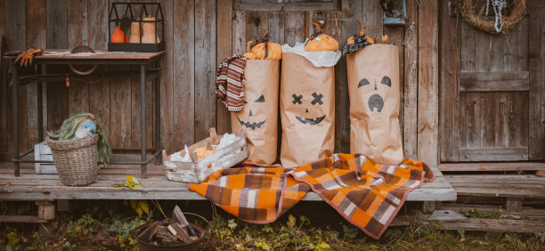万圣节的照片区与节日手工用具。牛皮纸纸袋上画着杰克南瓜鬼脸，万圣节怪物装饰图片下载