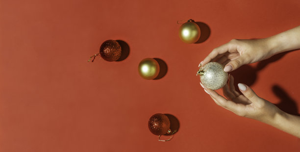 旗帜与球圣诞红背景。时髦时髦的女性美甲。美丽的年轻女子的手。圣诞新年主题。图片下载