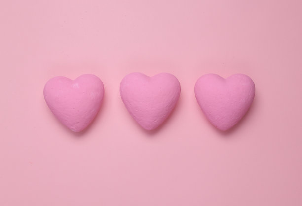 粉色背景上有三颗粉色的心。最小的爱静物图片下载