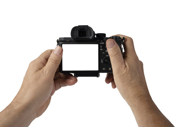 一名男子手持无反光镜相机，双手放在透明的背景上图片下载