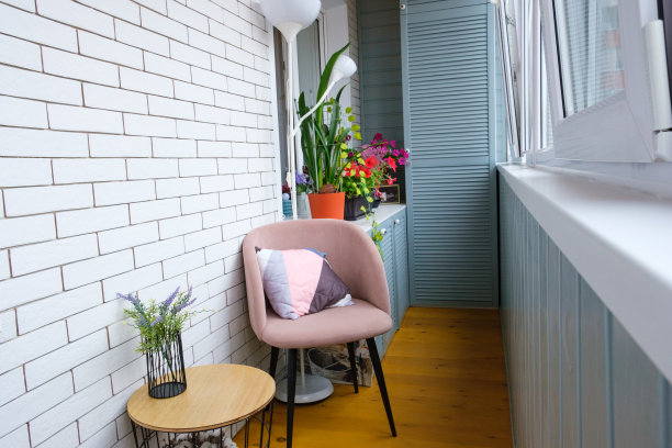 舒适的阳台内部，砖白色的墙，木地板，座椅区与扶手椅和咖啡桌图片下载