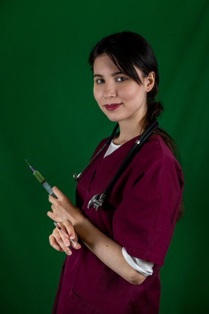 护士穿着防护服，拿着疫苗和注射器。图片下载