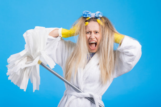 一个穿着晨袍、头带、蓬头垢面、紧张不安的女人，用拖把、女佣、家庭帮佣和因缺乏家人帮助而生气的妻子开始了一天的清洁工作图片下载
