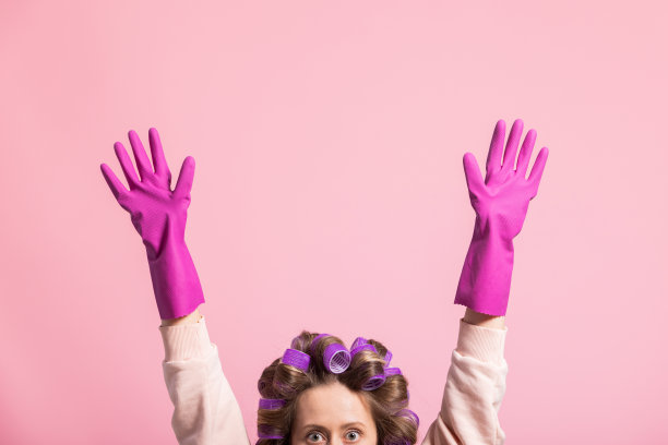 白人年轻女子的手戴着隔离的粉红色背景清洁手套，在家里清洁，洗碗图片下载