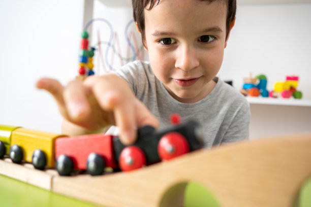 小孩在玩木制玩具火车图片下载