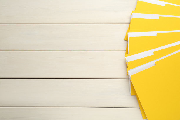 黄色文件和文件放在白色木桌，俯视图。空间的文本图片下载
