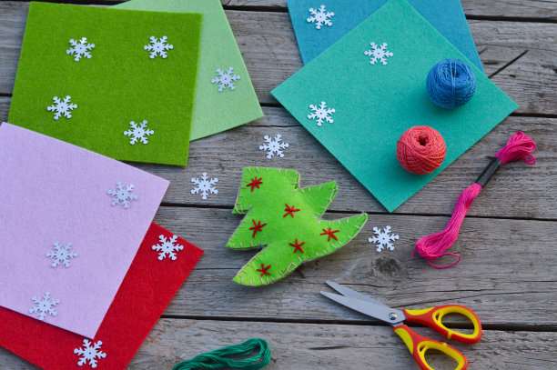 毛毡床单，剪刀，木桌上的线。给孩子们的新年手工创意。图片下载