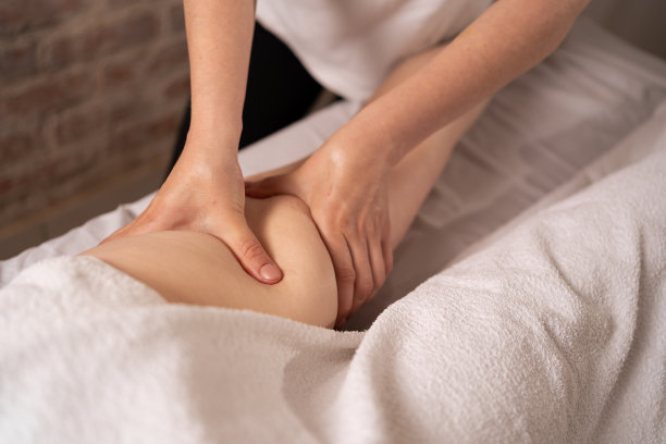 按摩师对患者的臀部和大腿进行减脂按摩。超重的治疗。抗脂肪按摩年轻女子在水疗沙龙。近距离图片下载