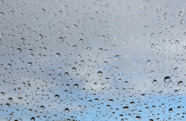 透过被雨滴覆盖的窗户看天空和云图片下载