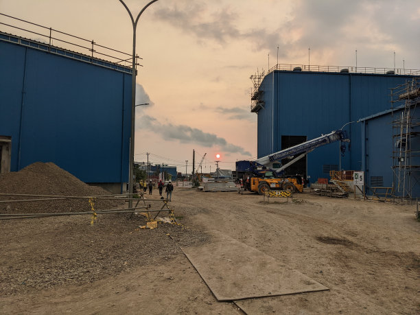 电厂建筑景观照片，蓝色、橙色和红色的天空。图片下载