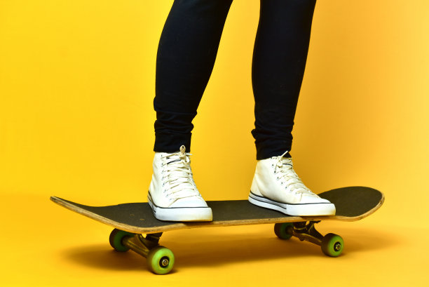 滑冰女孩的腿穿着白色运动鞋在黄色的背景。图片下载
