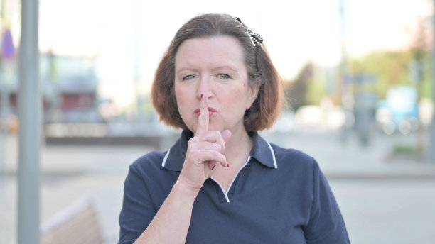 户外大妈，手指放在嘴唇上，请安静图片下载