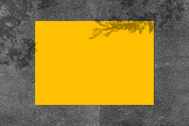 空的黄色方形海报模型与黑色混凝土墙背景上的光影。图片下载