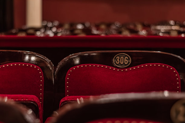 空荡荡的电影院大厅，红色的座位和模糊的背景车牌图片下载