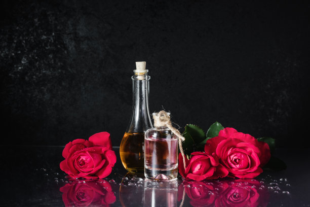 一瓶瓶香水和红玫瑰。图片下载