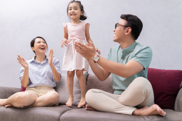 年轻的亚洲家庭坐在沙发上图片下载