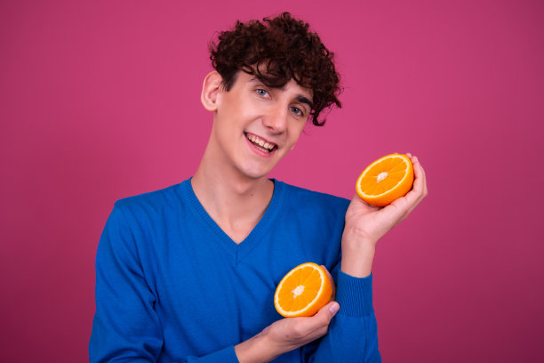 年轻有魅力的家伙和多汁的橘子。图片下载