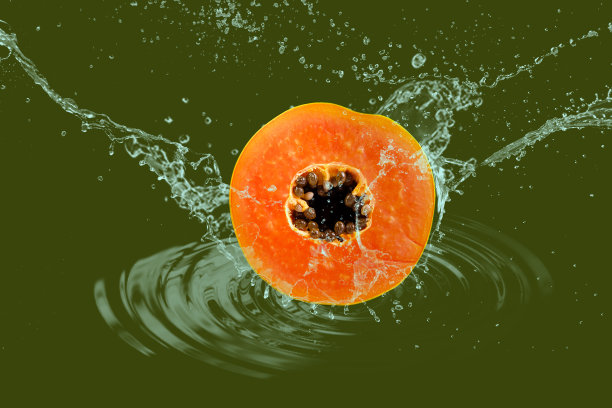 用溅起的水将成熟的木瓜切片图片下载