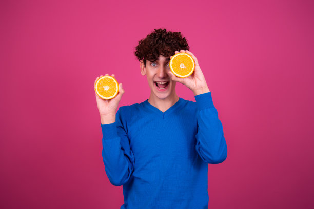 年轻有魅力的家伙和多汁的橘子。图片下载