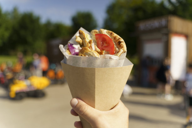 希腊街头小吃陀螺仪在手。希腊和地中海美食，皮塔饼夹肉。图片下载