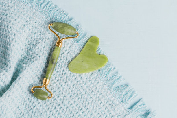 碧绿的玉面辊和浅蓝色背景上的刮刀图片下载