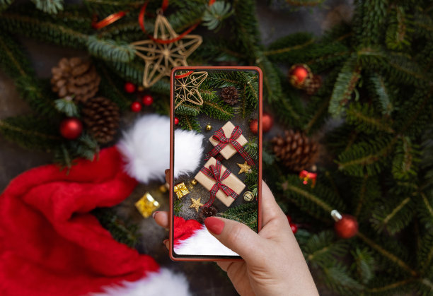 女人的手正在拍摄圣诞构图俯视图的移动照片图片下载