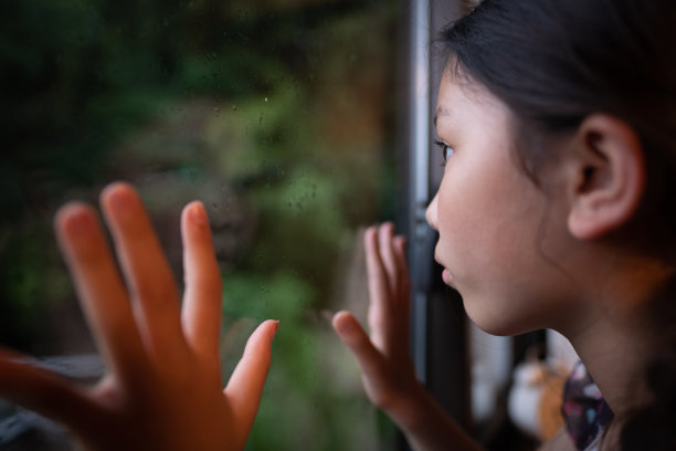 一个孩子望着窗外的雨景图片下载