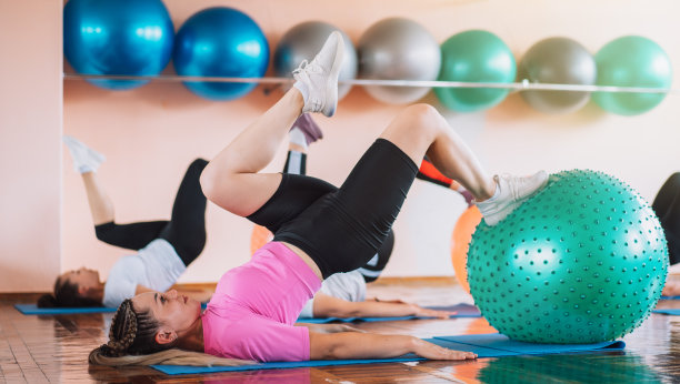 一群用健身球躺在垫子上健身的妇女图片下载