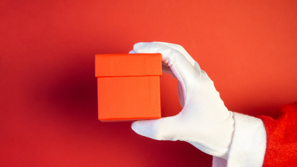 圣诞老人手拿圣诞礼品盒。图片下载