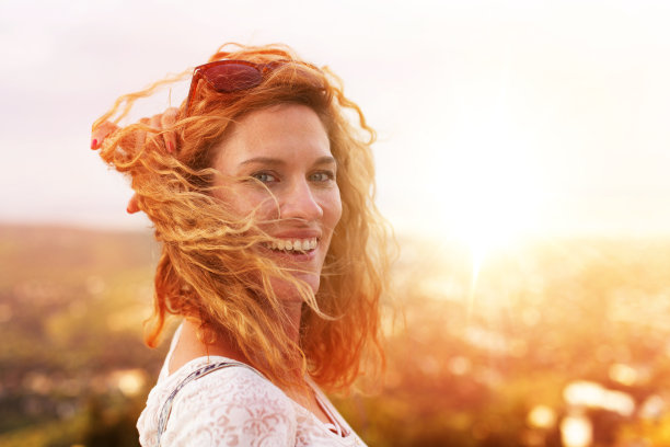 快乐的年轻红发都市女性在风中回头图片下载