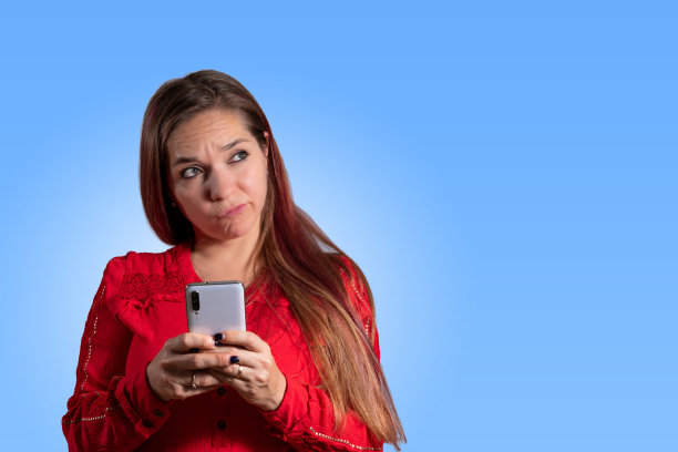 年轻女子拿着手机在思考。图片下载