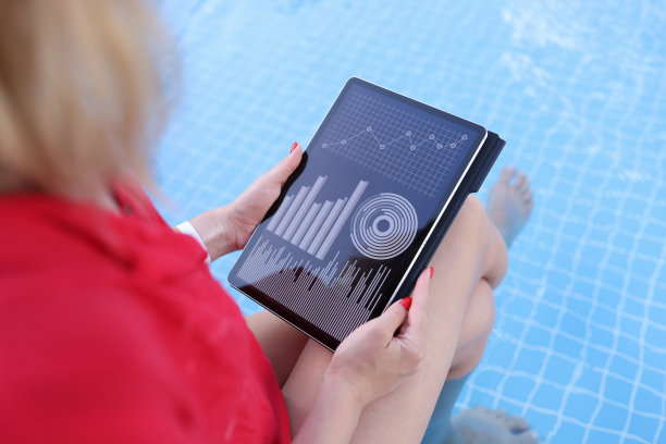 一名女子坐在游泳池边上用平板电脑浏览网页统计数据图片下载