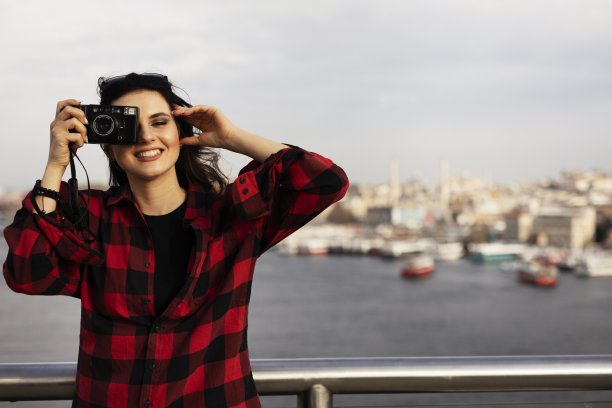 美丽的女孩在城市里拍照。图片下载