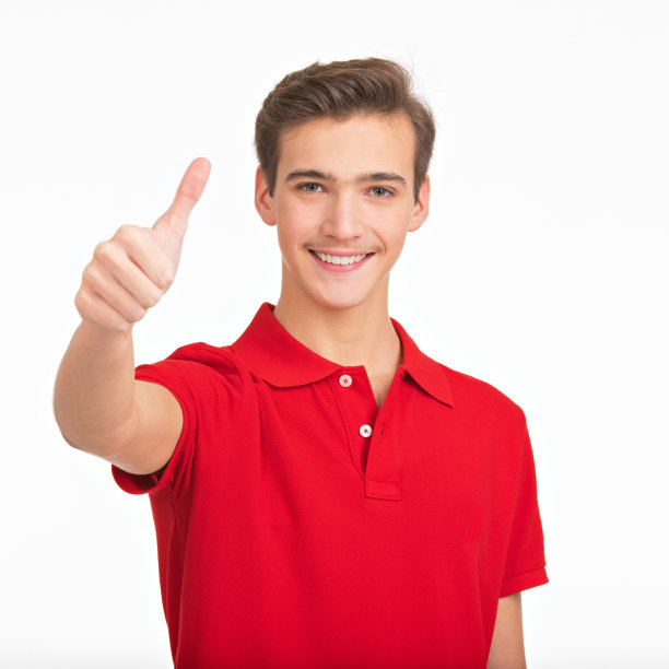 画像的快乐的年轻人显示大拇指的手势，孤立的白色背景。穿着红衬衫，竖起大拇指的英俊白人。积极的男性露出大拇指。图片下载