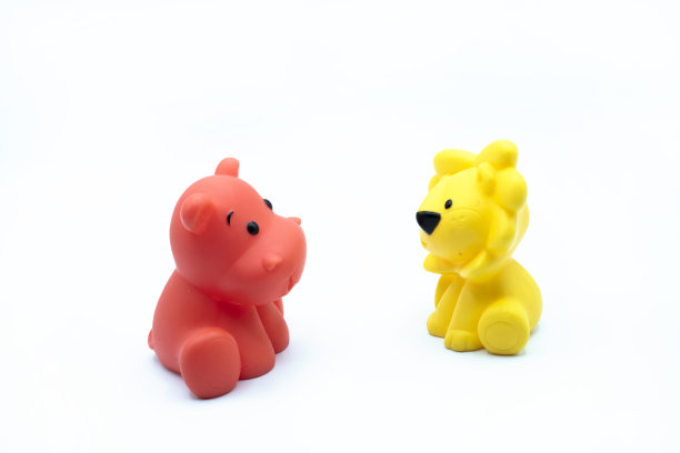 两个小玩具动物互相看着对方，在白色的背景中被隔开图片下载